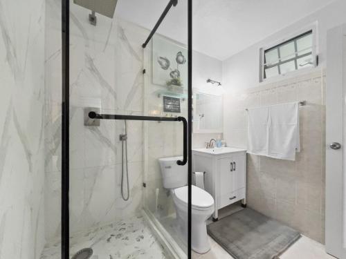 Un baño blanco con ducha y WC. en Tropical Naguabo Beach House Pool n Beach, en Naguabo