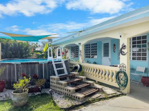 a house with a ladder next to a swimming pool at Tropical Naguabo Beach House Pool n Beach in Naguabo