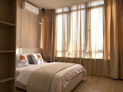 una camera da letto con un letto e una grande finestra di buzand9703 a Yerevan