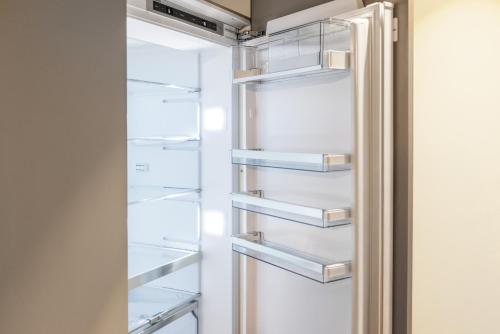 un refrigerador vacío con la puerta abierta en Visionary Hospitality Bassersdorf, Zürich - Premium Apartments in Swiss Style with Free Parking, Washer, Kitchen, Terrace, Vaulted Cellar Event Room, Bus Stop, 15' City & Airport, en Bassersdorf