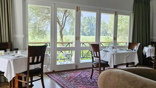 蒙塔古Montagu Vines Guesthouse的餐厅里有桌椅和窗户。