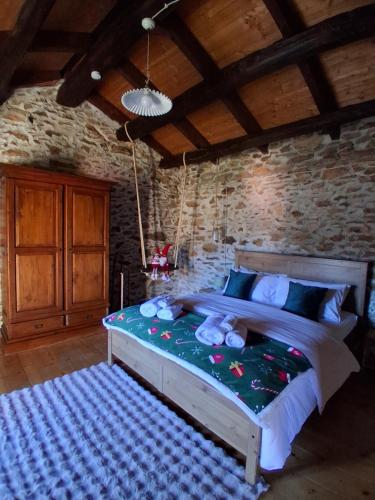 Il Rustico في Colleretto Castelnuovo: غرفة نوم بها سرير كبير وبه حيوانات محشوة