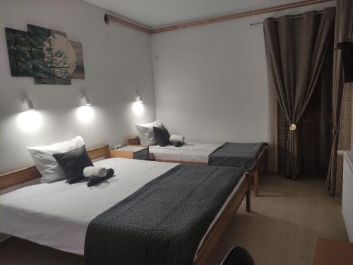 two beds in a small room with at Vila Čair DOPLATA ZA BAZEN in Soko Banja