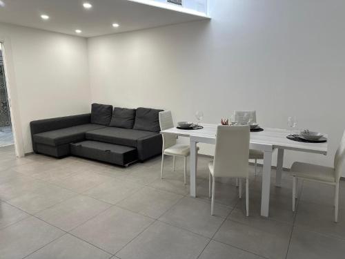 a living room with a couch and a table and chairs at Sea House Superior in Pietra Ligure