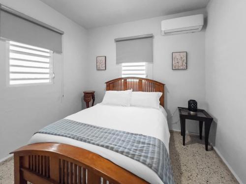 Un dormitorio con una cama grande con sábanas y almohadas blancas. en Casa Luquillo Cozy Retreat House With Pool n Tub, en Luquillo