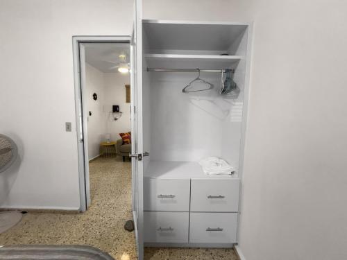 una habitación con un armario con cajones blancos y una puerta en Casa Luquillo Cozy Retreat House With Pool n Tub, en Luquillo