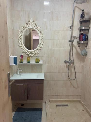 a bathroom with a sink and a shower with a mirror at Apartment with piscine in Mansouria