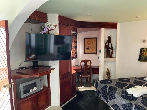 a bedroom with a flat screen tv on a entertainment center at Hotel Las Flores in Xalapa