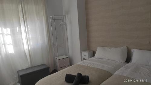 Un dormitorio con una cama con una cruz negra. en Vive Huelva MARINA WIFI 300 VFTHU01194, en Huelva