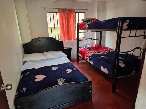 a bedroom with two bunk beds and a window at Finca Las Hamacas- La Posada del pensamiento in Santa Beatríz