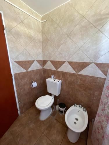 a bathroom with a toilet and a sink at Cabañas El Pela in Villa Carlos Paz
