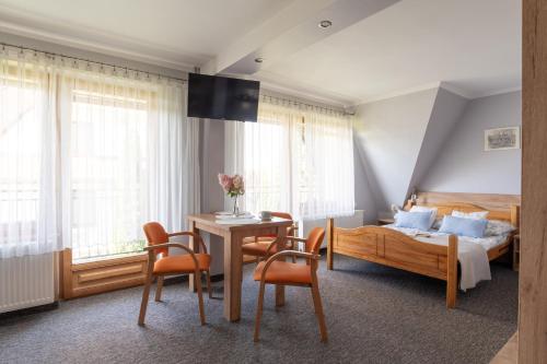 Willa Widok في بوكافينا تترايسكا: غرفة نوم بها سرير وطاولة وكراسي