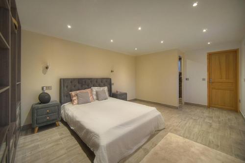 a bedroom with a large bed and a wooden door at FRGK Villa Contemporaine Studio Indépendant Piscine, Calme Vue Dégagée in Le Cannet