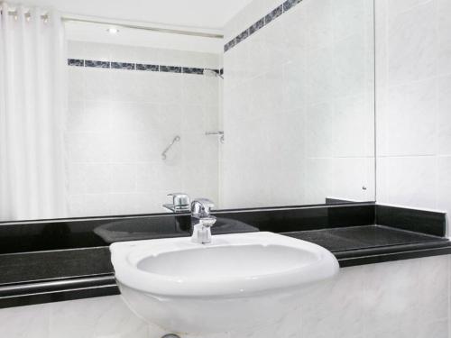 a white bathroom with a sink and a shower at Leonardo Hotel East Midlands Airport in Castle Donington