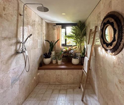 Un baño con ducha con plantas. en Why Not Villas, en Ubud