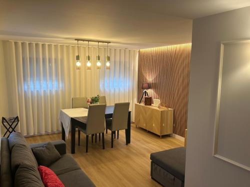 a living room with a table and a couch at Casa da Vila do Rock in Paredes de Coura