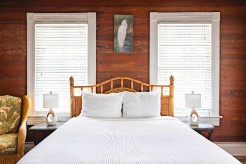 a bedroom with a large bed and two windows at Curry House - Rooms 3 & 4 in Key West