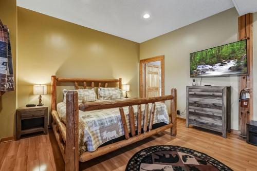 a bedroom with a bed and a dresser and a television at Tranquil View by American Patriot Getaways in Glade