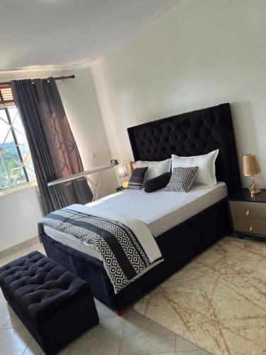 坎帕拉Green vee apartment的一间卧室，配有一张大床和一扇窗户。