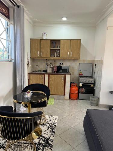 坎帕拉Green vee apartment的客厅里有一张桌子和一个厨房