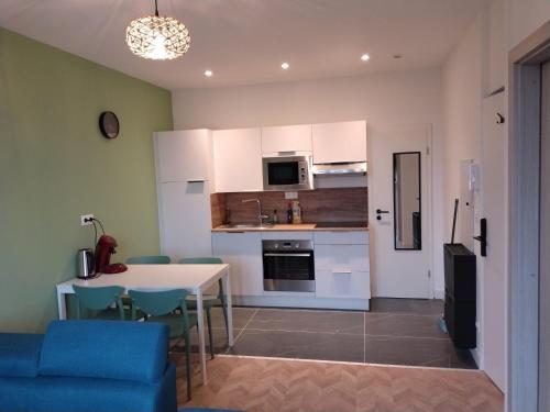 a kitchen with a table and chairs and a kitchen with white cabinets at Appartement spacieux in Lille
