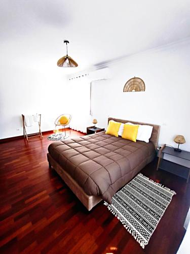 a large brown bed in a room with wooden floors at PESO RIVER HOUSE in Melgaço