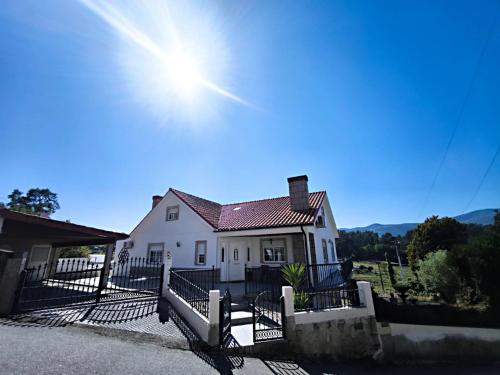 a white house with the sun in the sky at PESO RIVER HOUSE in Melgaço