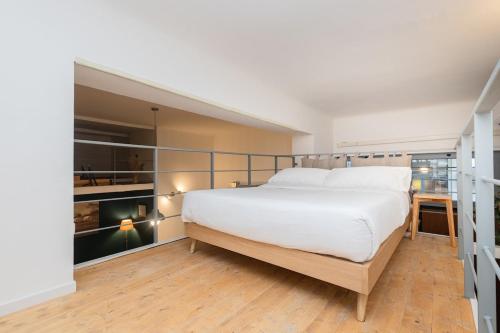 una grande camera da letto con un grande letto bianco di Living Bovisa a Milano