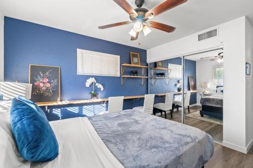 een blauwe slaapkamer met een bed en een plafondventilator bij Pool & Fire Pits • Pet Friendly • 3 BR Home in Las Vegas