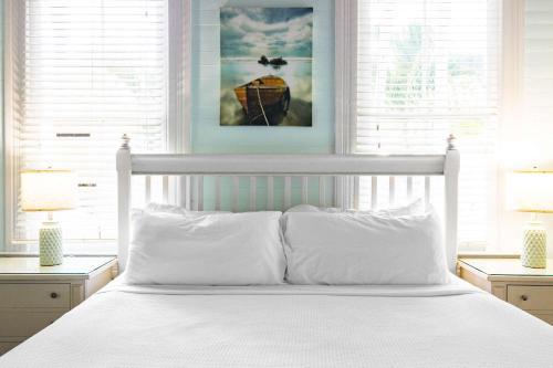 a white bed with white pillows in a bedroom at Curry House - Room 5 in Key West
