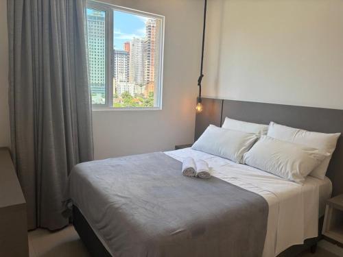 Un dormitorio con una cama con dos zapatos encima. en Apto c/ parrilla a 450 m del mar, Perequê SRF0601, en Perequê