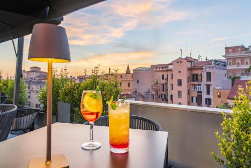 a table with two drinks on a balcony with a view at Hotel Raffaello - Sure Hotel Collection by Best Western in Rome