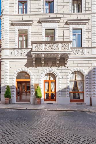 a building with a balcony and doors on a street at Hotel Raffaello - Sure Hotel Collection by Best Western in Rome