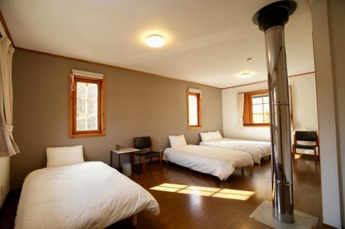 a room with three beds with white sheets at THE KOYA Nagano in Nagano