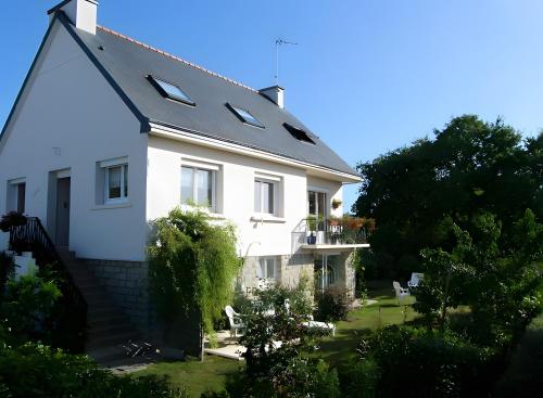 een wit huis met een zwart dak bij Ty Annick chambres d'hôtes in Kermen