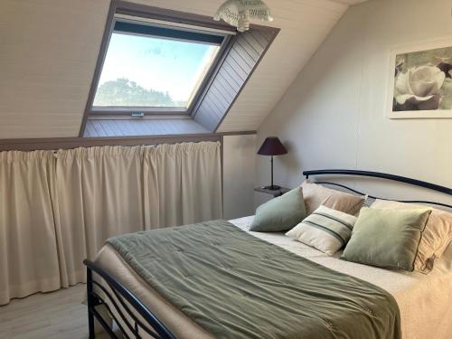een slaapkamer met een groot bed en een raam bij Ty Annick chambres d'hôtes in Kermen