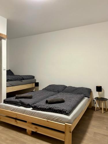 two beds in a room with a white wall at Na Zlaťáku in Malá Morava