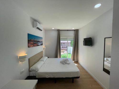 a small room with a bed and a window at Lux Hostal in Hospitalet de Llobregat