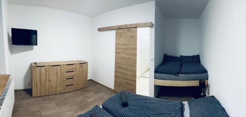 een slaapkamer met een stapelbed en een houten kast bij Na Zlaťáku in Malá Morava