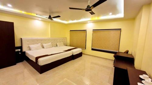 Un dormitorio con una cama y un ventilador de techo. en Hotel Royal - View - Residency & Restaurant Bodh Gaya Near Temple & The Great Buddha Statue Fully Air Conditioning Rooms- Premium Quality Hotel Inn Bodh Gaya, en Bodh Gaya