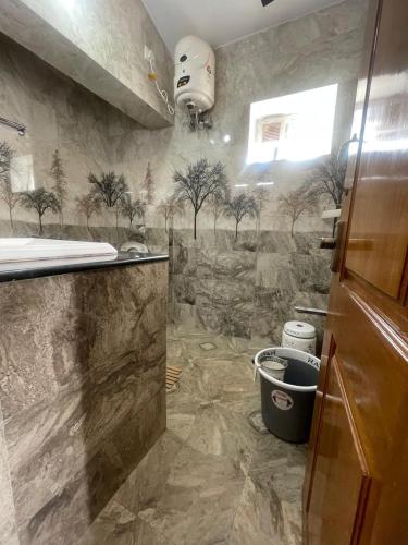 a bathroom with a tree mural on the wall at IndivaStays - Moon Stone Villa in Ooty