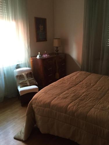 a bedroom with a bed and a chair and a dresser at B&B san Biagio parma in Parma