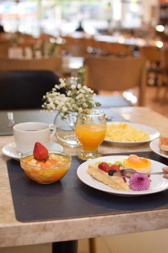 una mesa con platos de comida y fruta. en Howard Johnson Ciudad del Este, en Ciudad del Este