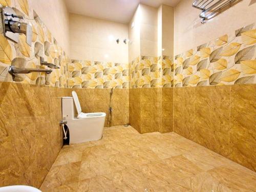baño con aseo y pared de piedra en Hotel Royal - View - Residency & Restaurant Bodh Gaya Near Temple & The Great Buddha Statue Fully Air Conditioning Rooms- Premium Quality Hotel Inn Bodh Gaya, en Bodh Gaya