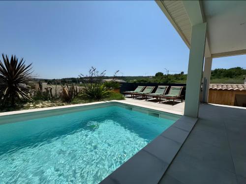 een zwembad aan de zijkant van een huis bij Villa Hestia in Goudargues
