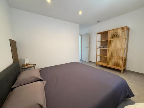 een slaapkamer met een groot bed en een boekenplank bij Villa Hestia in Goudargues
