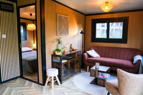 een woonkamer met een bank en een bed bij 'De Schuif' in Berlicum