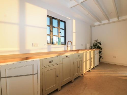 eine Küche mit einer Theke mit Spüle und einem Fenster in der Unterkunft Farm house in Newick