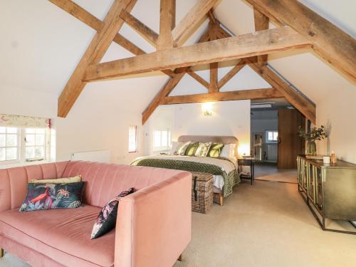 ein Wohnzimmer mit einer rosa Couch und einem Bett in der Unterkunft Farm house in Newick