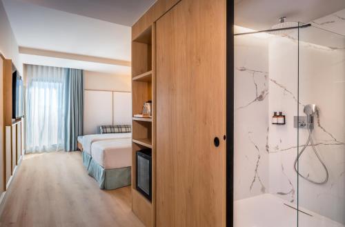 a hotel room with a bed and a shower at Barcelo Valladolid in Valladolid